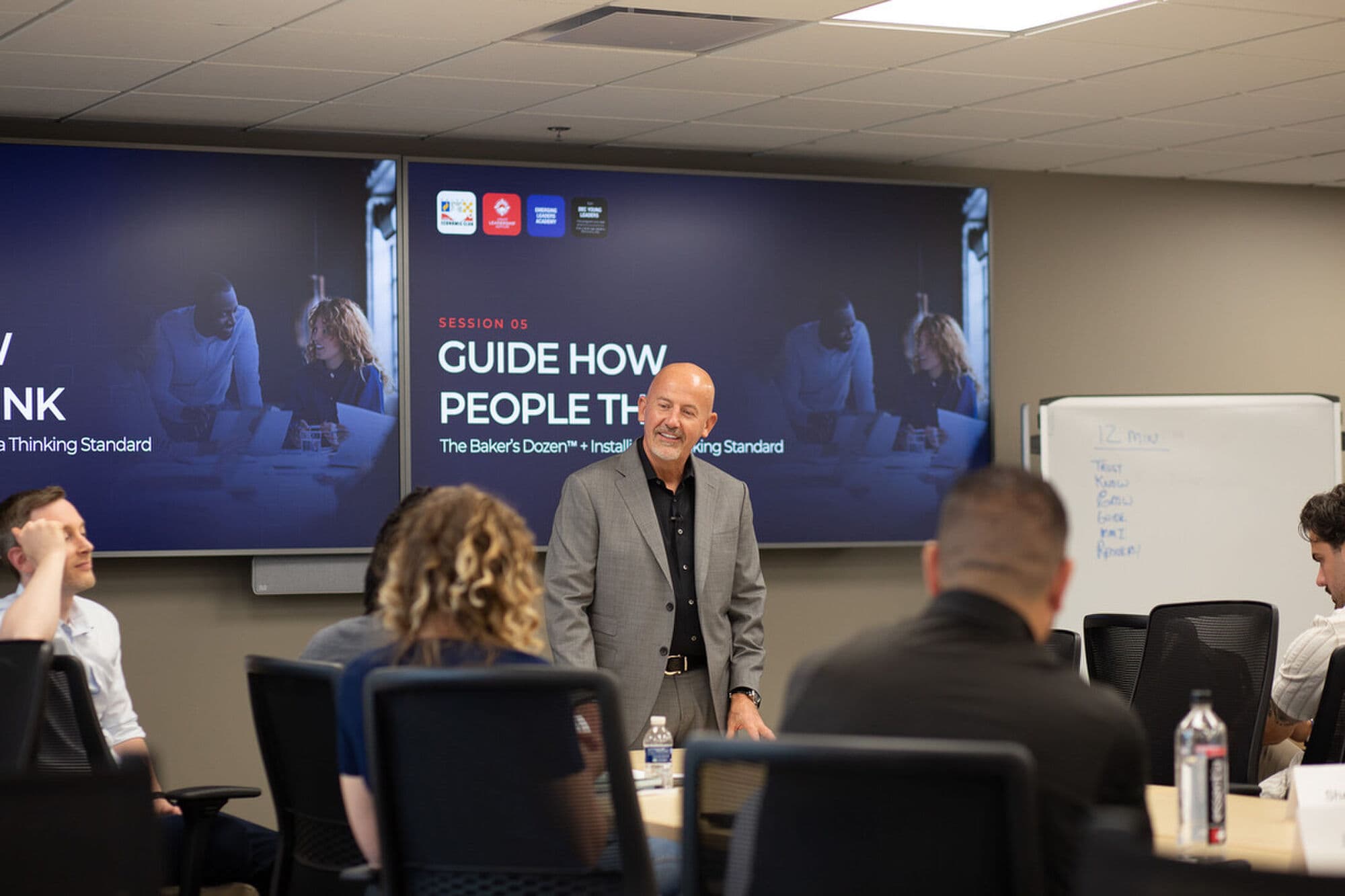 Steve Lowisz teaching the thinking standard in front of a Guide How People Think session screen